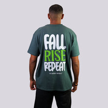 Load image into Gallery viewer, Person wearing a green t-shirt with 'Fall Rise Repeat' text on the back against a gray background