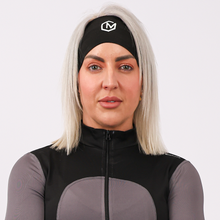 Load image into Gallery viewer, Woman wearing a black and gray athletic outfit with a white logo on a light gray background