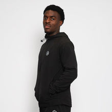 Load image into Gallery viewer, Person wearing a black tracksuit with a logo on a white background