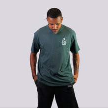 Load image into Gallery viewer, Man wearing a green t-shirt with a logo on a plain background
