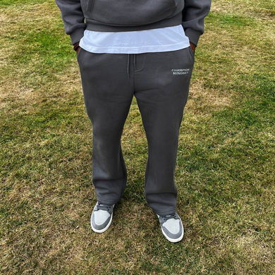 Person  pants standing on grass with trees in the background