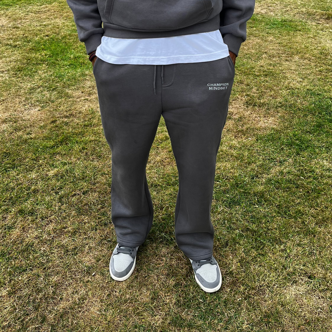 Person  pants standing on grass with trees in the background