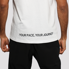 Load image into Gallery viewer, Person wearing a white t-shirt with 'Your Pace, Your Journey' text on a plain background
